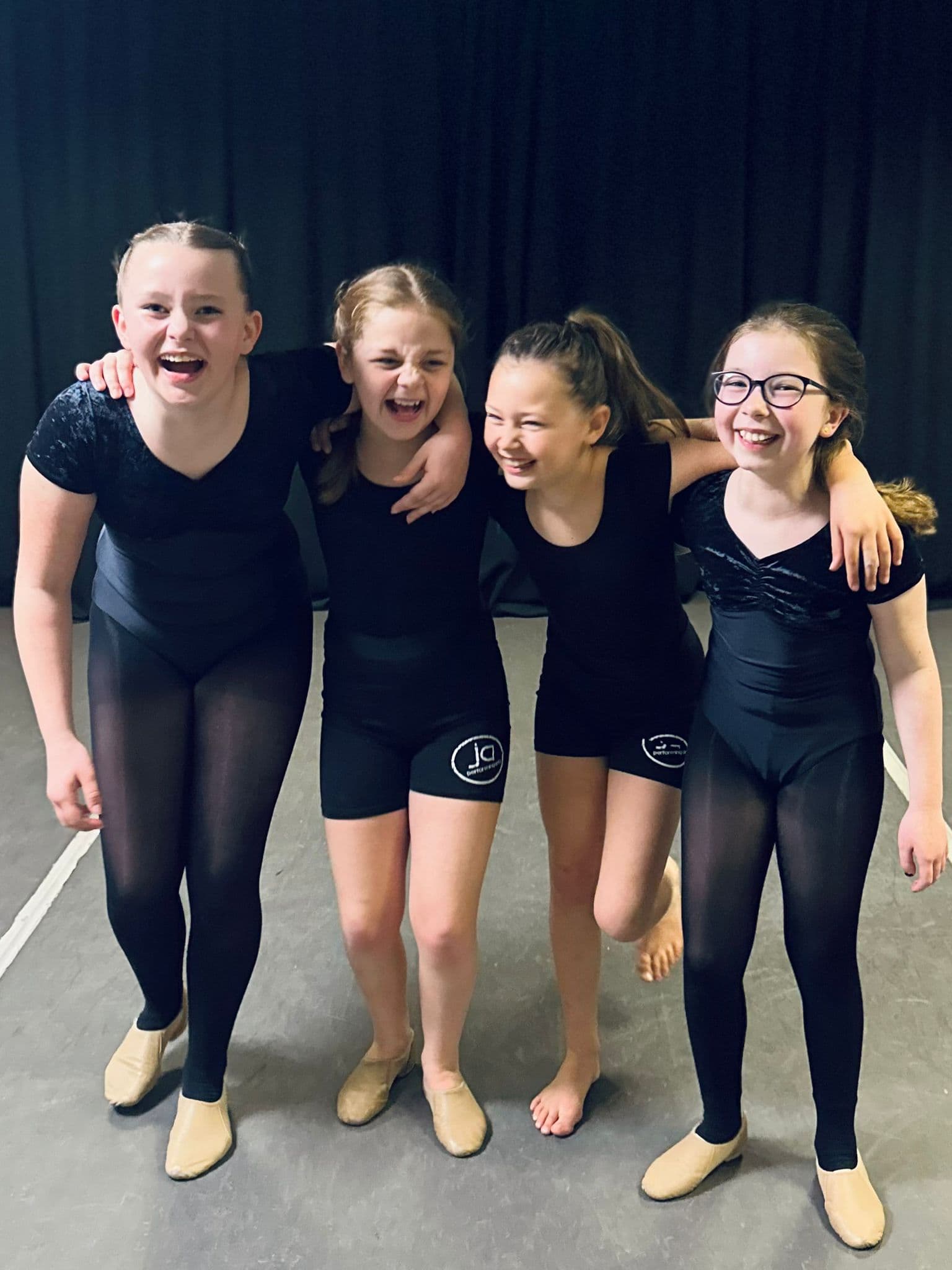 Upper Junior dancers laughing together in JA kit
